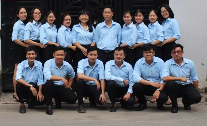 Nhóm nhân sự mặc áo sơ mi xanh chụp ảnh chung