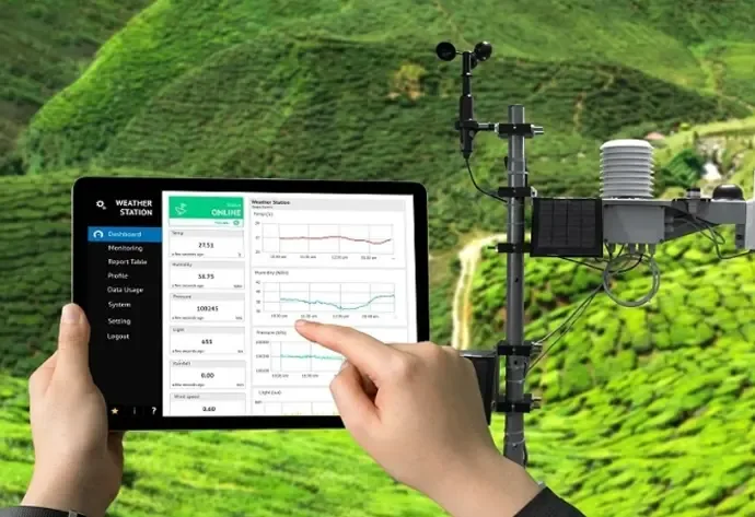Kỹ thuật viên cầm máy tính bảng xem dashboard trạm quan trắc ngay tại hiện trường, bên cạnh thiết bị đo ngoài trời